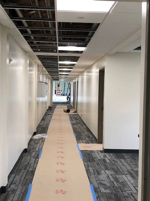 A hallway under construction, with flooring being put in.
